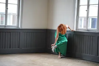 Andrea Kirste in grünem Kleid am Fenster